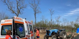 Tractor răsturnat peste doi bărbați care îl reparau